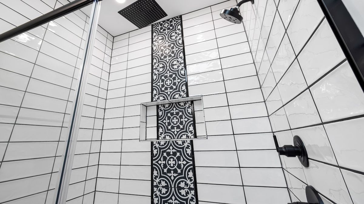 Zidana tu&scaron; kabina u crno-belom kupatilu