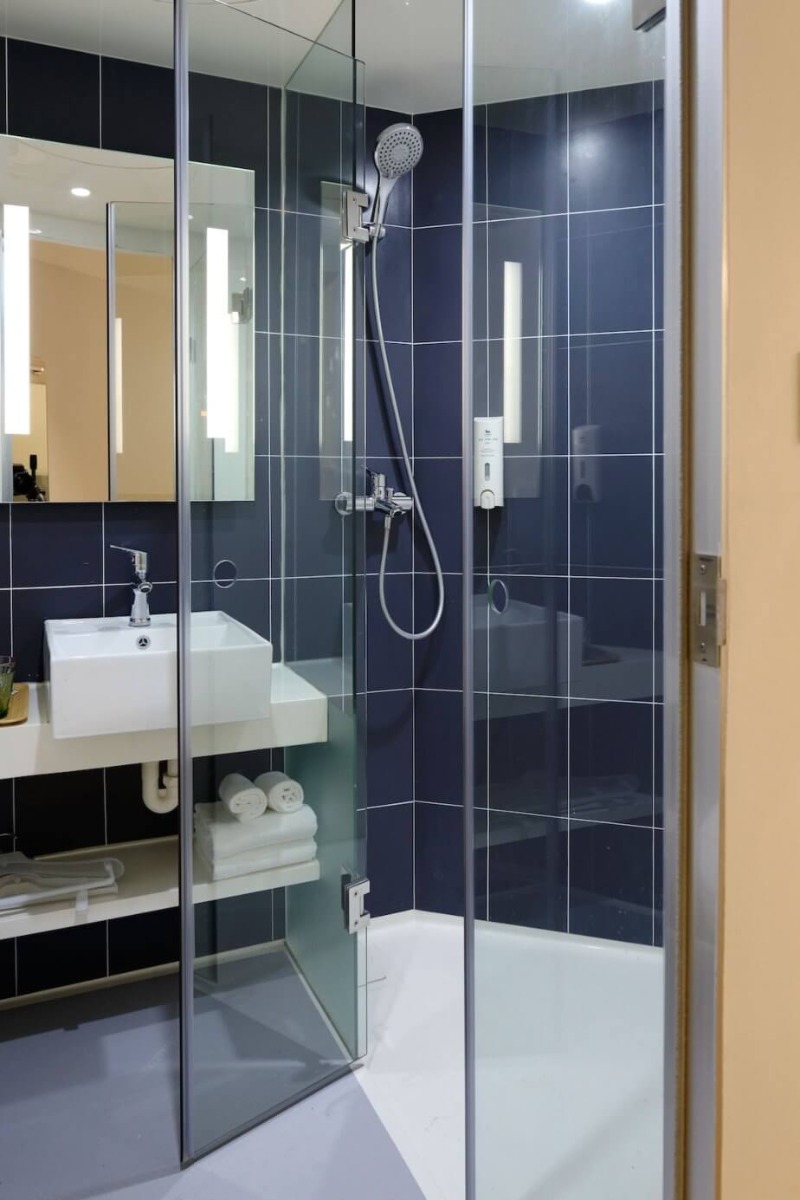 Tu&scaron; kabina u kupatilu sa teget pločicama